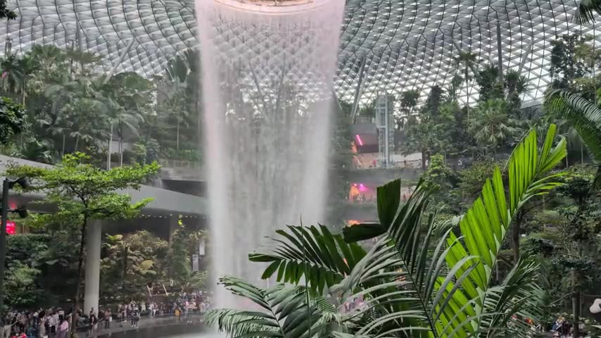 The indoor waterfall cascading through the lush botanical garden at Jewel Changi Airport, Singapore