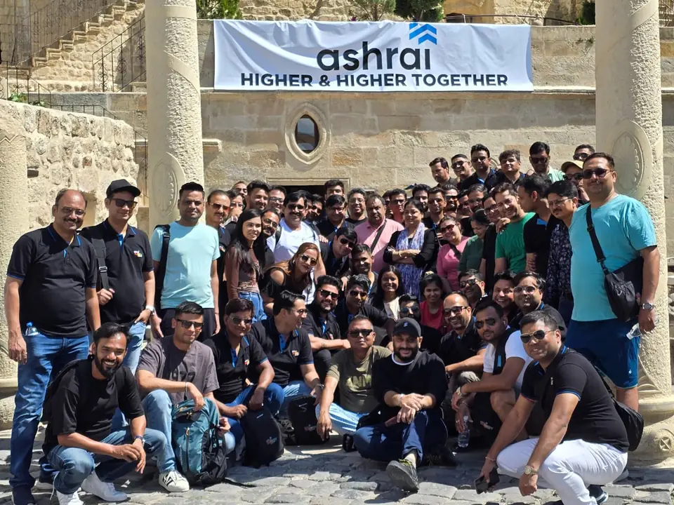 Ashrai channel partners gathered under an Ashrai banner in a stone courtyard in Turkey